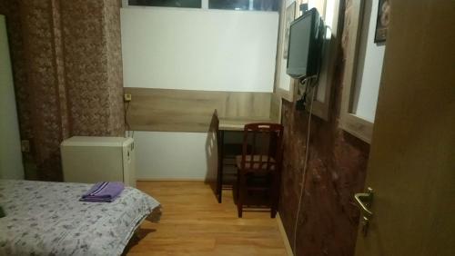 a small room with a bed and a television at SOBA ROYAL 5 in Šabac