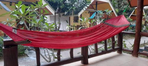 a red hammock hanging on a fence at Long Beach Garden Resort in Ko Lanta