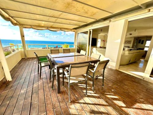 une salle à manger avec une table et des chaises sur une terrasse dans l'établissement POOL GYM AND BEACH FRONT 3 BEDROOMS LUXURY TEL AVIV APARTMENT, à Tel Aviv