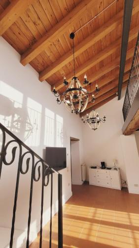 a living room with a wooden ceiling and a chandelier at CharmeRooms Villa Moroni La Depandance in Stezzano