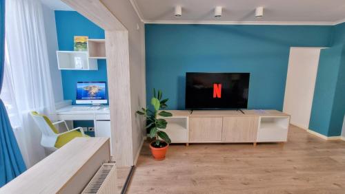 a living room with a tv on a blue wall at Central Chic Otopeni - Self Check-in, Netflix, HBO MAX in Otopeni