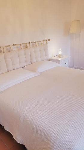 a white bed with white sheets and a lamp at CharmeRooms Villa Moroni La Depandance in Stezzano
