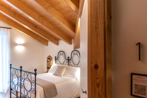 a bedroom with a bed with a wrought iron headboard at B&B El Lares - B&B L'Avez in Canale dʼAgordo