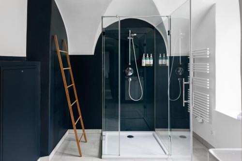 a glass shower in a bathroom with a ladder at numa I Sonate Apartments in Salzburg