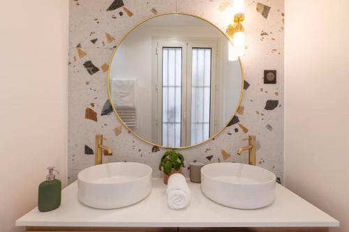 La salle de bains est pourvue de 2 lavabos et d'un miroir. dans l'établissement GemBnB Luxury Apartments - Résidence Rivoli, à Paris