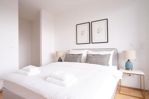 1 dormitorio blanco con 1 cama blanca grande con almohadas en Bright & Wonderful Apartment at Oberlaa Therme, en Viena