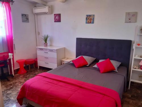 a bedroom with a large bed with red pillows at Villa élégante à Sainte-Anne avec piscine privée ouverte toute l'année in Sainte-Anne