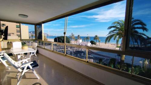 balcone con tavolo, sedie e vista sulla spiaggia di Principado Marina Benidorm Playa Poniente a Benidorm