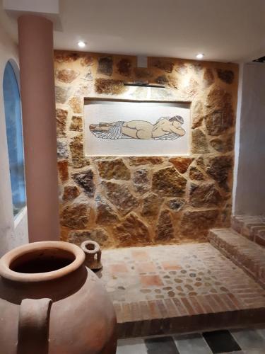 eine Steinmauer mit einer Vase in einem Zimmer in der Unterkunft Grand appart 4,6,8 personnes vue directe sur mer in Villajoyosa
