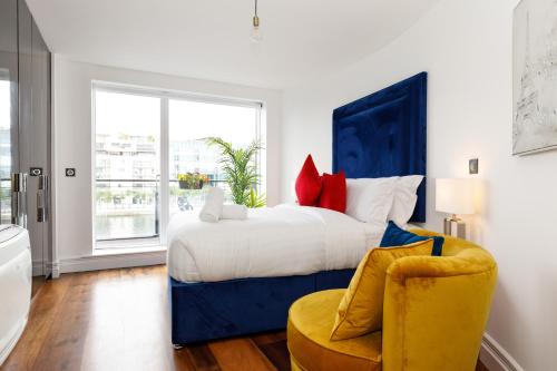 a bedroom with a large bed and a yellow chair at The Curve, Millennium Tower in Dublin