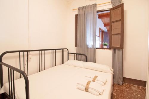 een bed met twee handdoeken in een kamer bij Global Properties, Apartamento céntrico en Canet d'en Berenguer in Canet de Berenguer