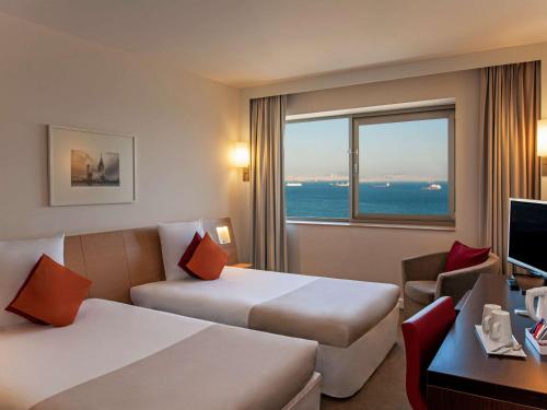Habitación de hotel con 2 camas y ventana en Novotel Istanbul Zeytinburnu, en Estambul