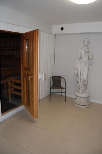 a statue of a woman in a room with a chair at Hotel Friesengeist in Wiesmoor