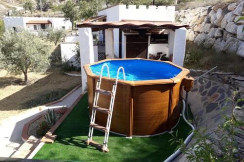 un bain à remous avec une échelle à côté d'une maison dans l'établissement Casa Caballo a private cottage in Lubrin, à Lubrín