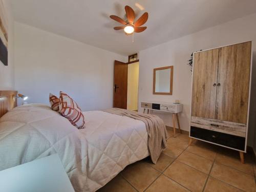 a bedroom with a bed and a ceiling fan at Casa Caballo a private cottage in Lubrin in Lubrín