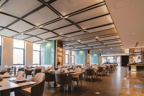 Wyndham Handan Congtai في هاندان: غرفة طعام مليئة بالطاولات والكراسي