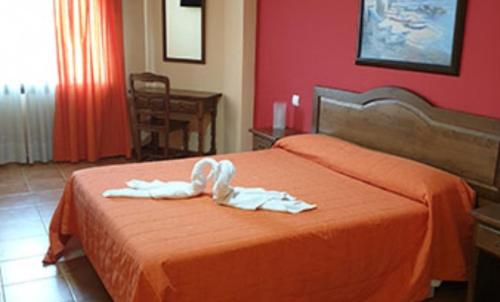 a hotel room with a bed with white towels on it at Hostal El Hidalgo in Villaluenga