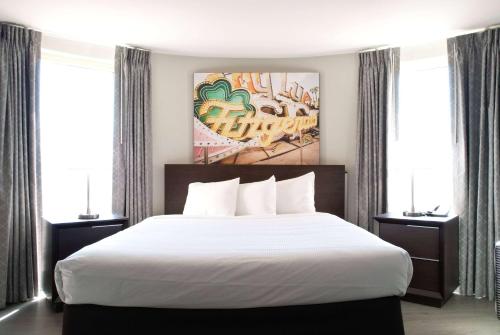 a bedroom with a white bed and two windows at Fitz Tunica Casino & Hotel, Trademark Collection by Wyndham in Tunica Resorts