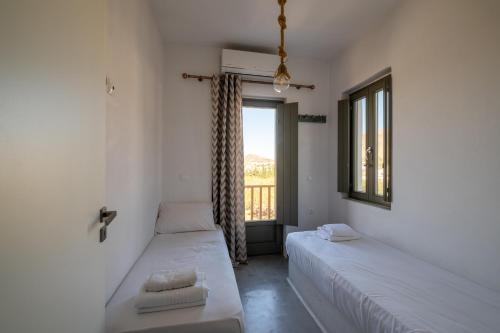 two beds in a room with a window at Villa Arkadia in Parasporos