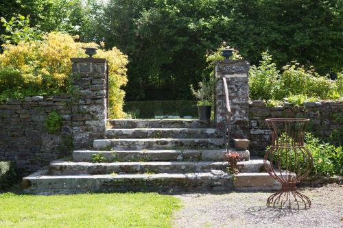 a set of stone stairs in a garden at Le Logis d'Equilly in Équilly