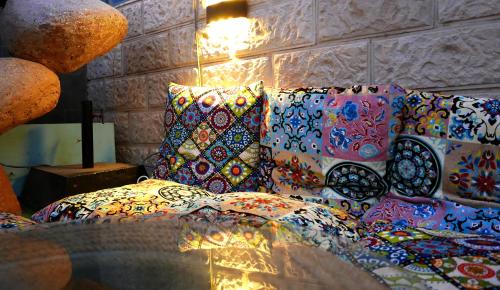 a room with a bed with colorful pillows on it at Skyrock Dahab in Dahab