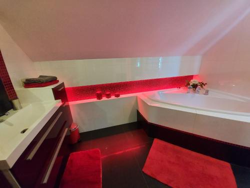 a bathroom with a tub with red lights in it at Chatka z Góralskim Klimatem in Żywiec