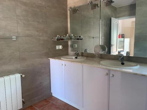 een badkamer met 2 wastafels en een grote spiegel bij villa Altea con piscina privada in Bernia