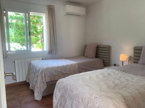 een slaapkamer met 2 bedden en een raam bij villa Altea con piscina privada in Bernia