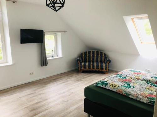 1 dormitorio con 1 cama y 1 silla en una habitación en Holzmichl, en Varel
