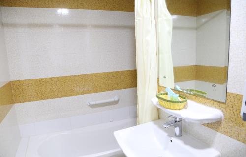 een badkamer met een wastafel, een toilet en een spiegel bij Sky Iconic in Dubai