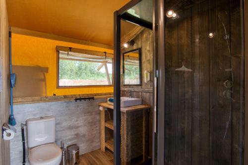 ein Bad mit einem WC und einem Waschbecken in der Unterkunft JOINS! Glamping Aquitaine in Saint-Aigne