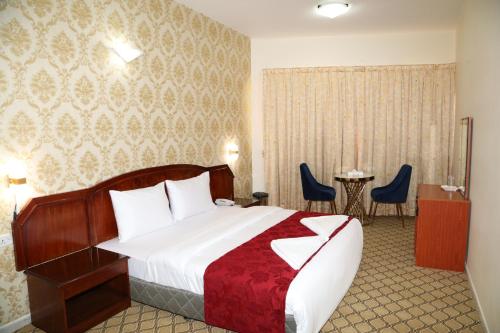 een hotelkamer met een bed en een tafel en stoelen bij Sky Iconic in Dubai