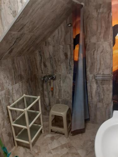 a bathroom with a shower and a stool in it at Апартамент Вангелов in Nesebar