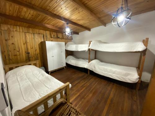two bunk beds in a room with wooden floors at CASA DE CAMPO POTRERILLOS in Potrerillos