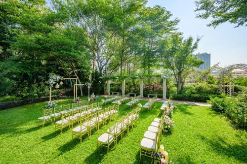 a row of tables and chairs for a wedding in the grass at Hong Kong Gold Coast Hotel in Hong Kong