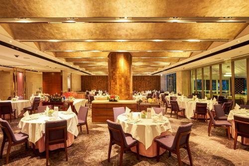 a dining room with white tables and chairs at Hong Kong Gold Coast Hotel in Hong Kong