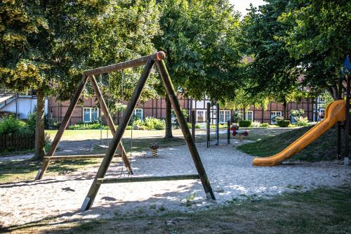 a park with two swings and a slide at Dreimädelhaus - Kirchseelte in Kirchseelte