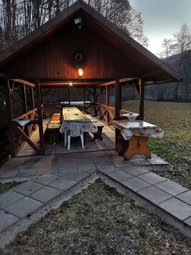 a pavilion with a picnic table and a bench at Fontana Erdélyi Vendégház 2 in Satu Mare