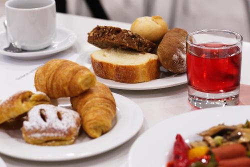 uma mesa com dois pratos de pastelaria e um copo de água em International Atene hotel em Atenas