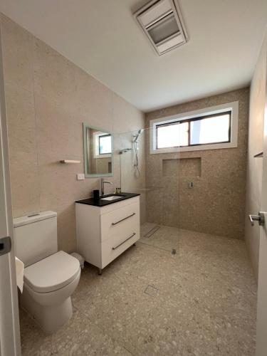 a bathroom with a toilet and a glass shower at Vineyard stay at Mudgee in Apple Tree Flat