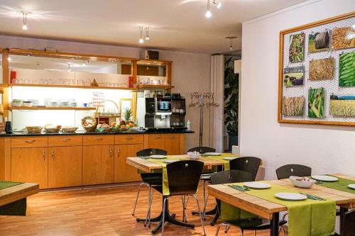 eine Küche und ein Esszimmer mit Holztischen und Stühlen in der Unterkunft Centra Hotel Zurich in Bassersdorf