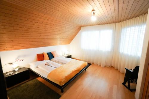 1 dormitorio con 1 cama grande y techo de madera en Centra Hotel Zurich, en Bassersdorf