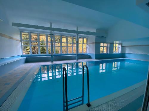 a swimming pool with blue lighting in a building at Apartman Poustevnik in Pec pod Sněžkou