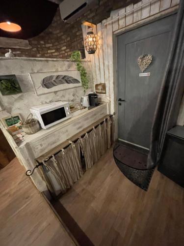 a kitchen with a counter with a microwave and a door at Au Bien-Etre D’Elise - Chambre d’hôte in Fayat