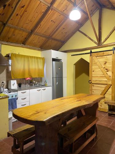 cocina con mesa de madera en una habitación en Los Tres Chiflados Chascomús en Chascomús