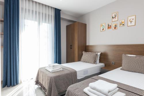 een hotelkamer met 2 bedden en een raam bij BİSUİTES in Antalya
