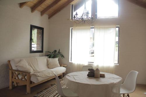 sala de estar con sofá blanco y mesa en Cabaña El Rey y las golondrinas en Lago Puelo