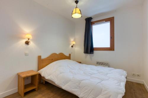 une chambre avec un lit blanc et une fenêtre dans l'établissement Les Alpages du Corbier A102, à Villarembert