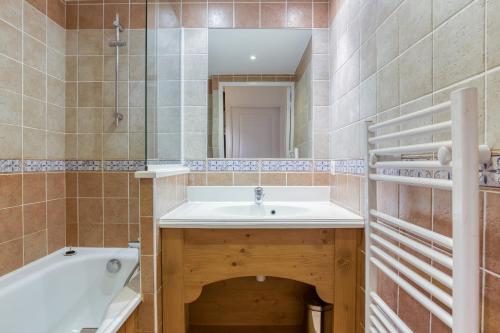 une salle de bain avec un lavabo, une baignoire et un miroir dans l'établissement Les Alpages du Corbier A102, à Villarembert