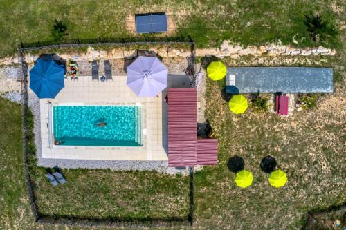 - une vue sur la piscine bordée de parasols dans l'établissement JOINS! Glamping Aquitaine, à Saint-Aigne